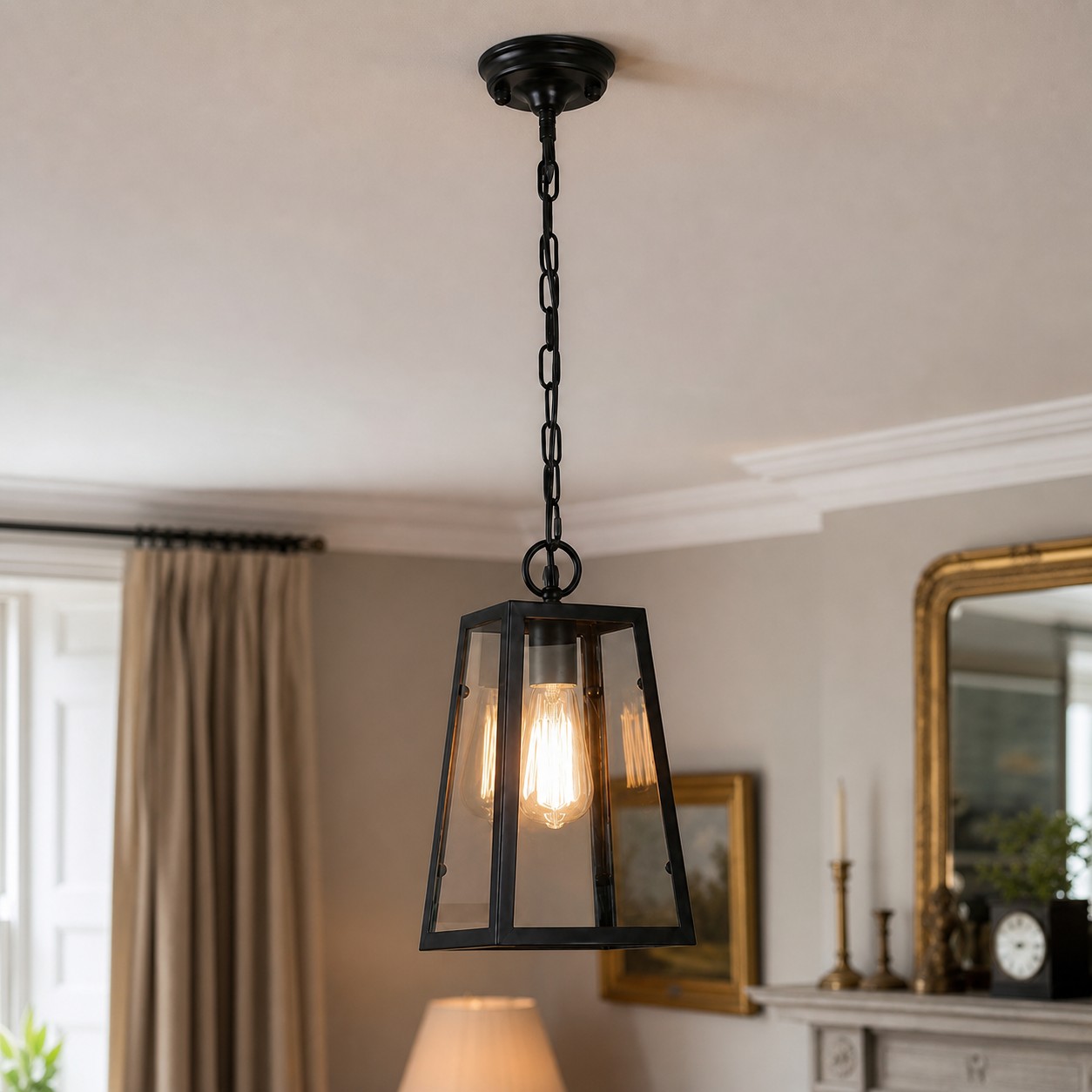Black glass pendant light above a console and mirror